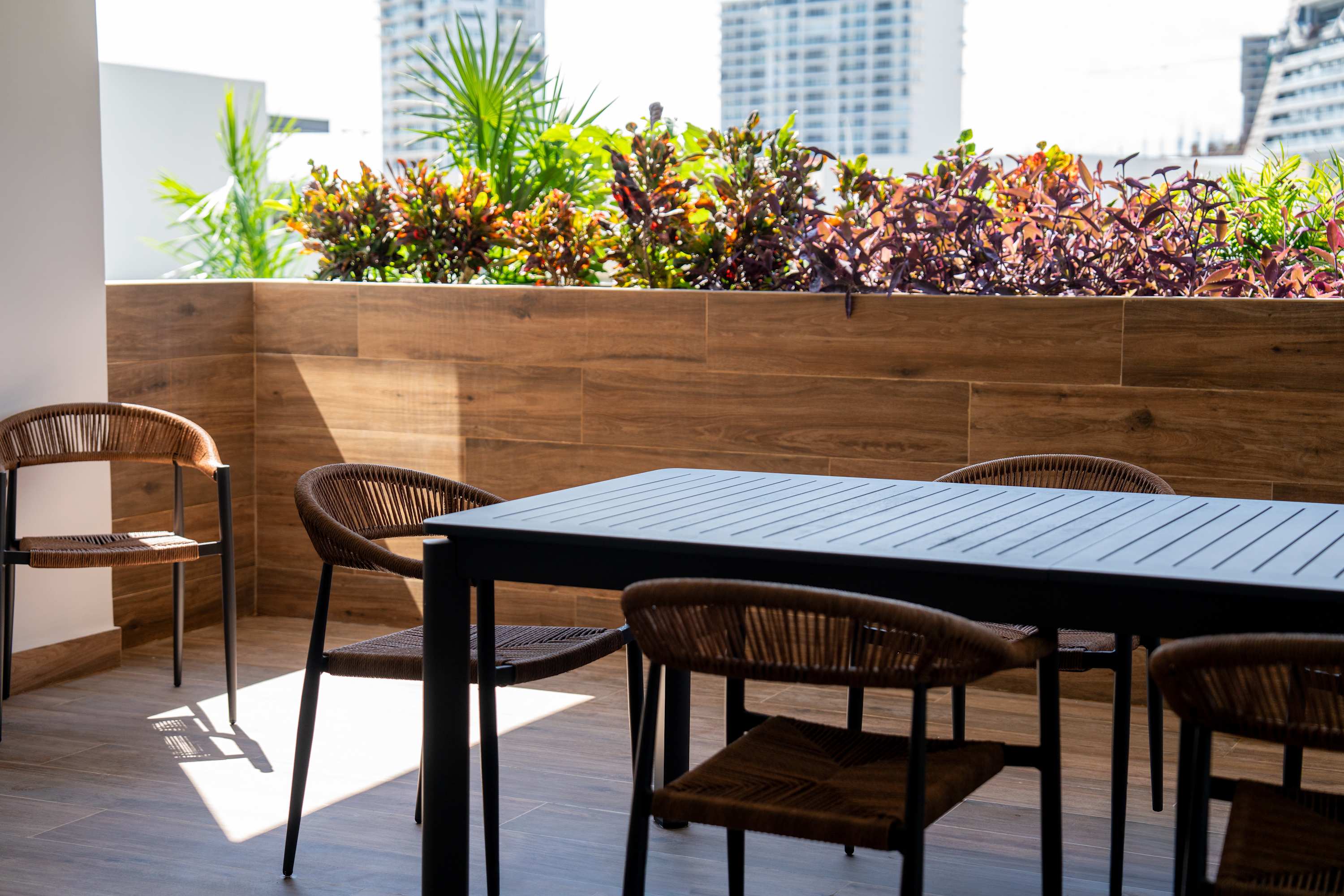 An outdoor dining area with a table and chairs on a tiled patio.