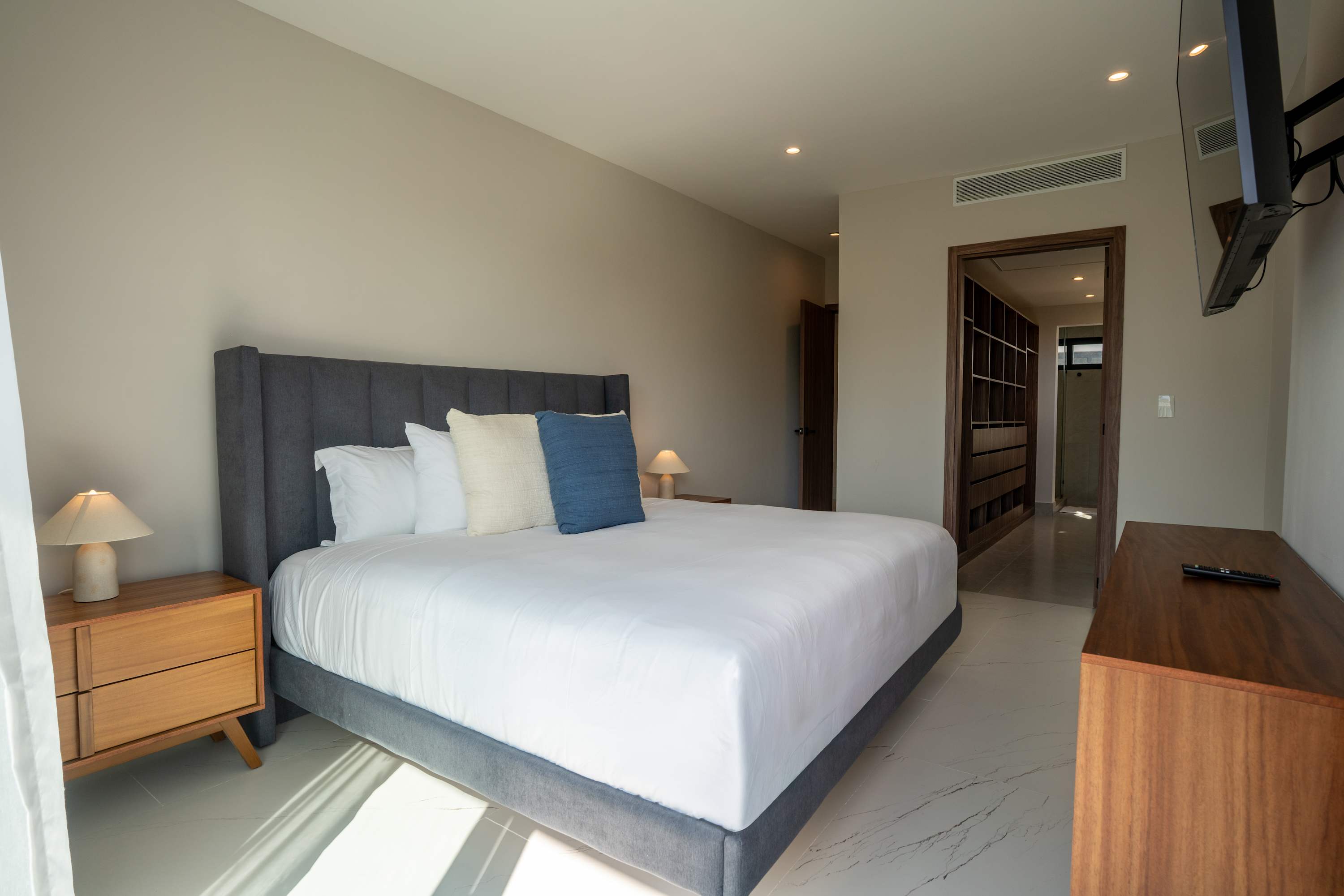 A bedroom features a large bed, a TV, and a closet.