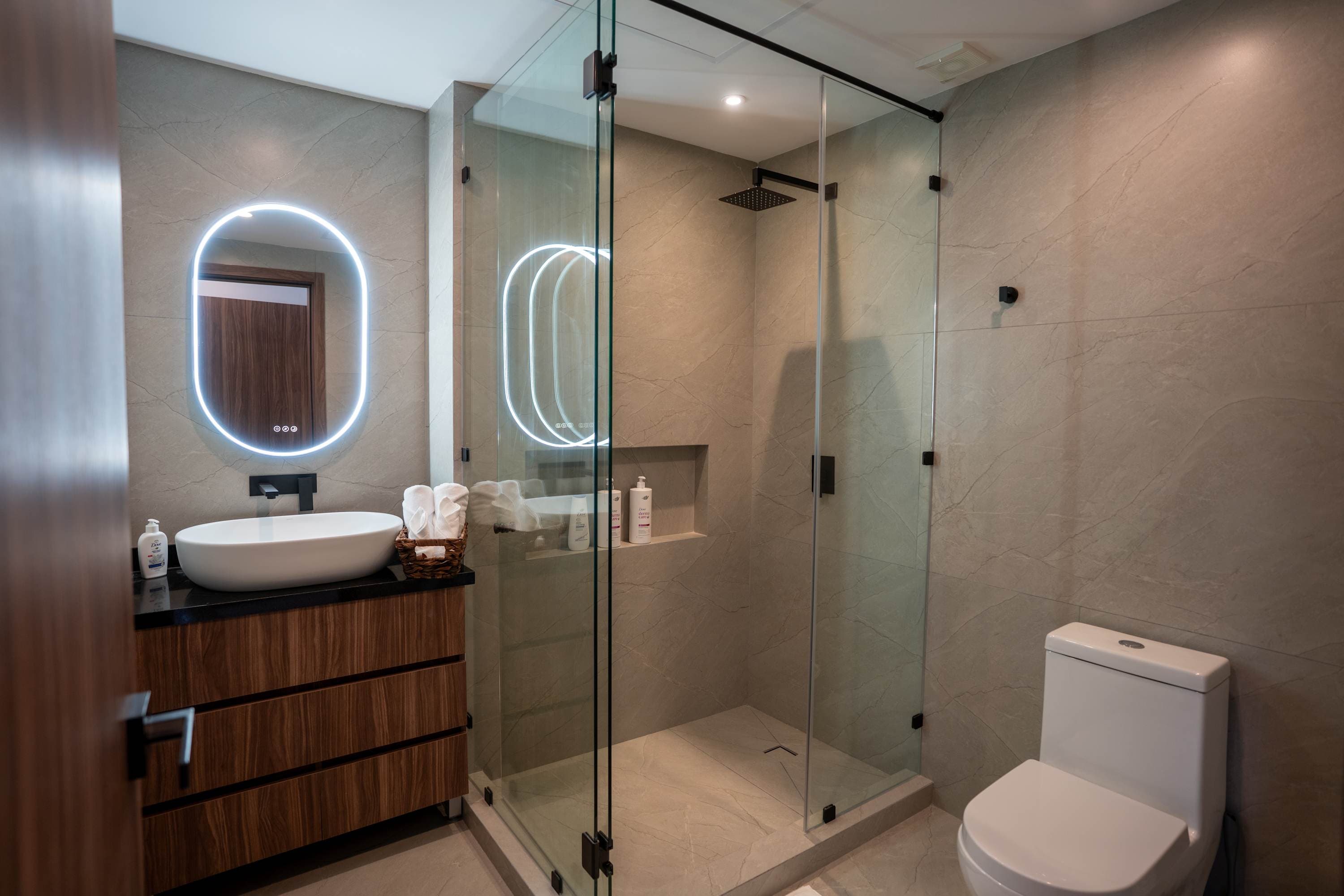 Bathroom with a sink, toilet, and glass shower stall.