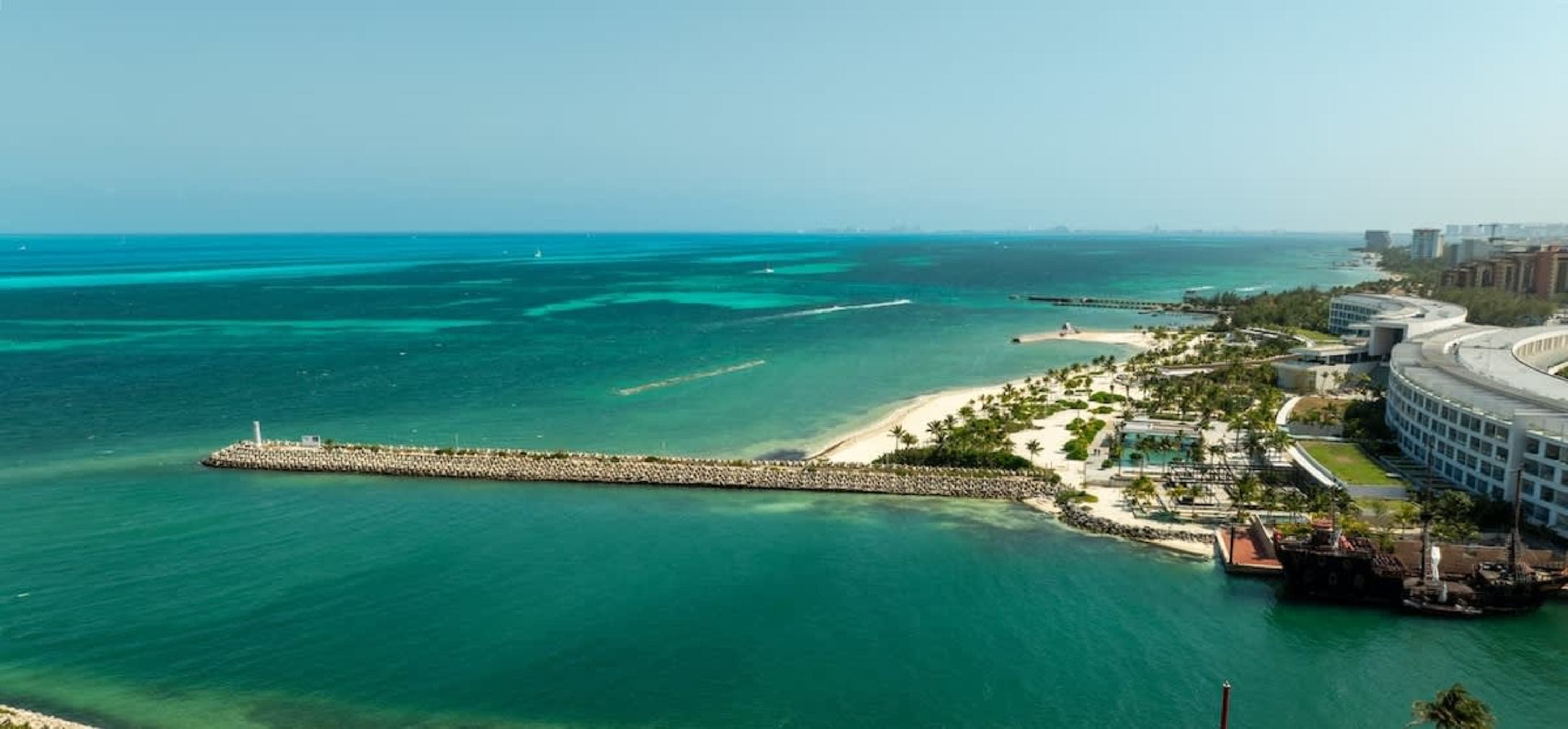 A scenic aerial view of a tropical resort with turquoise waters, sandy beaches, and modern architect