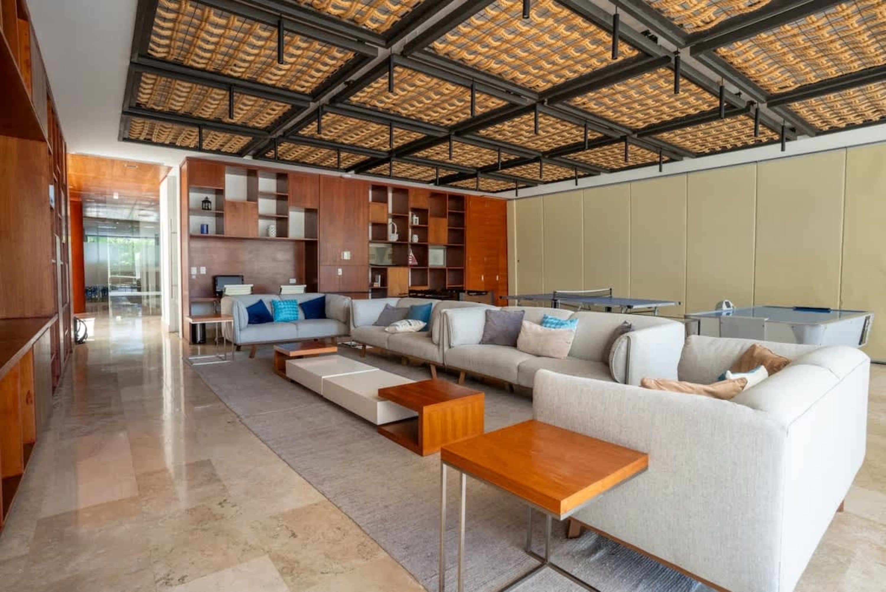 Modern lounge area with couches, coffee tables, ping pong and pool tables.