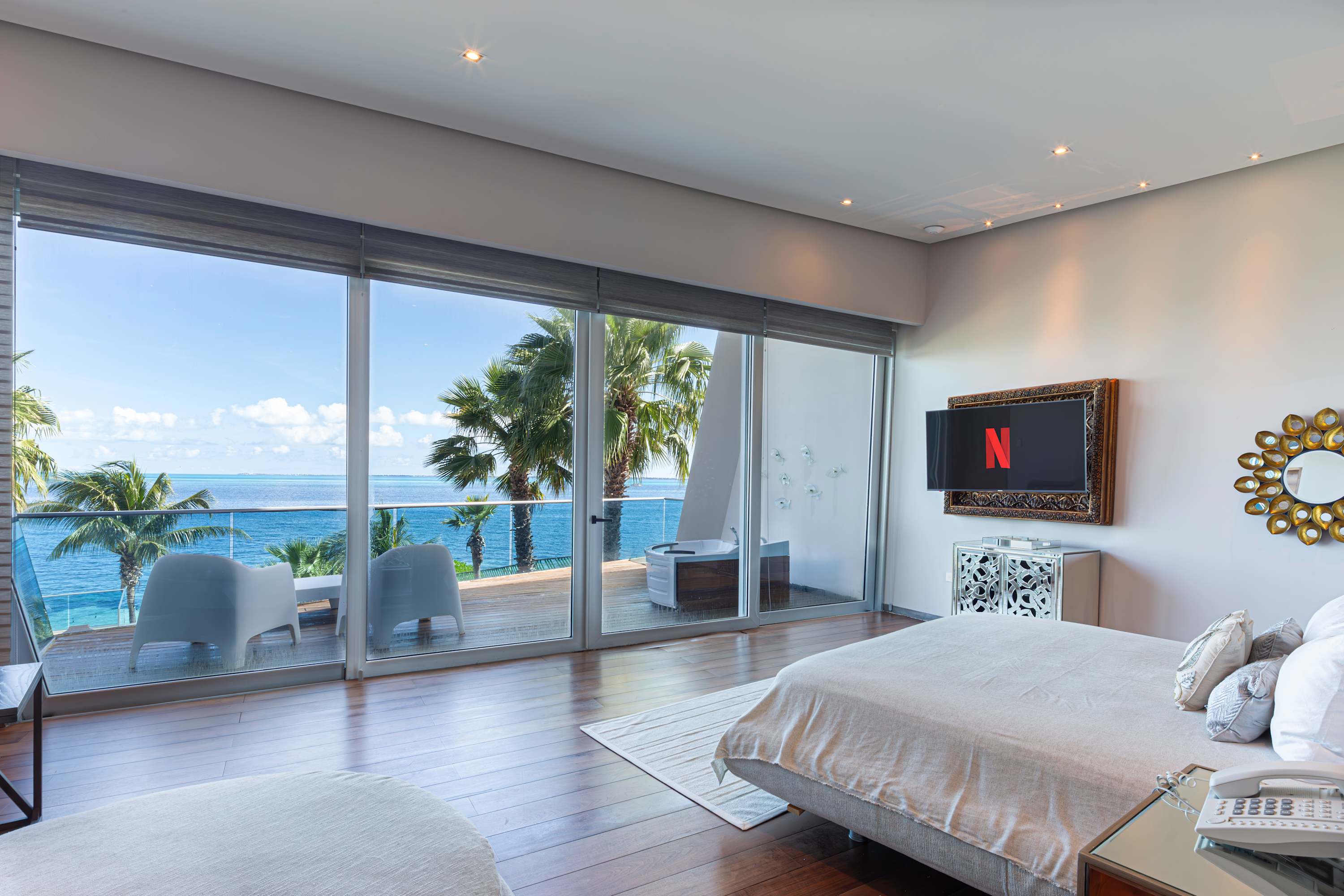Luxurious bedroom with a stunning ocean view, a large bed, and a TV.