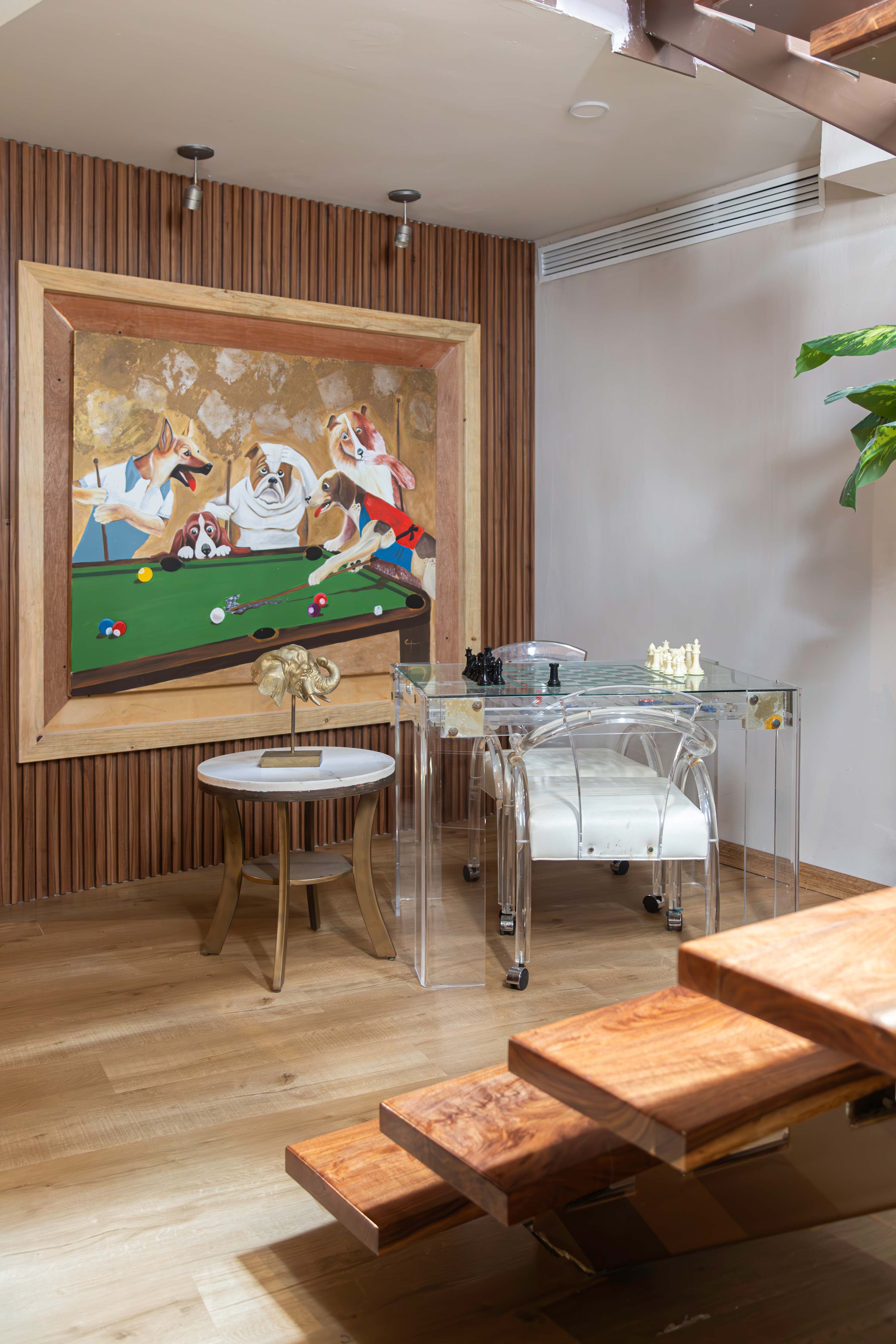 A modern game room with a painting of dogs playing billiards.
