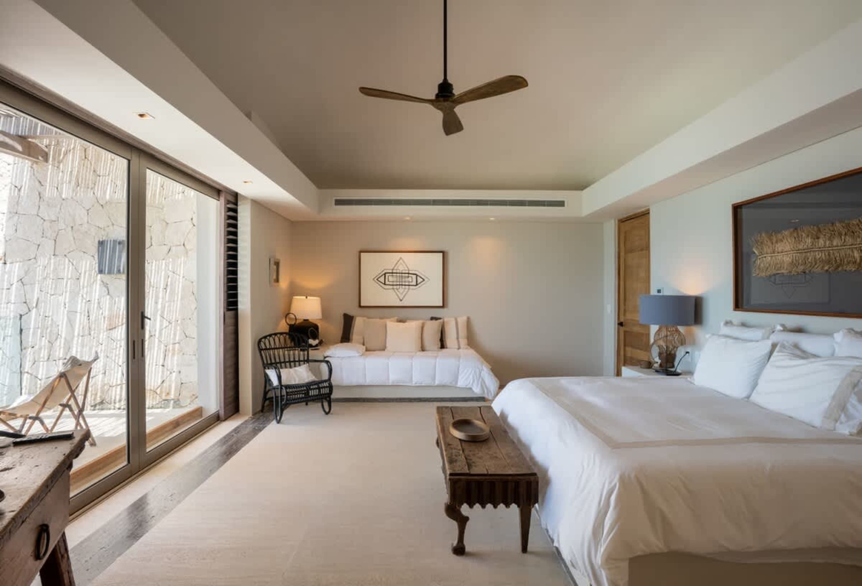 Luxury bedroom with large windows, a king-size bed, and a daybed.