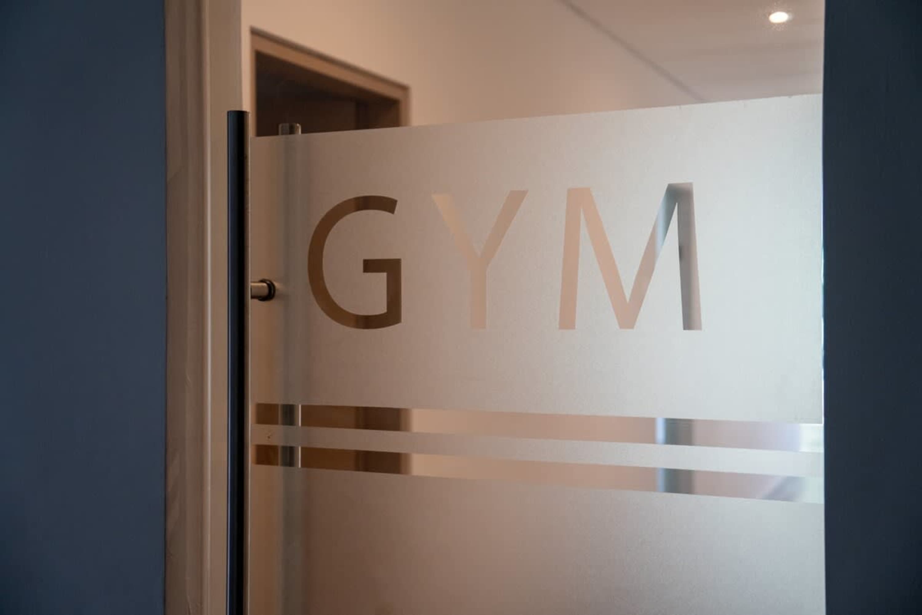 A frosted glass door with the word "GYM" on it.