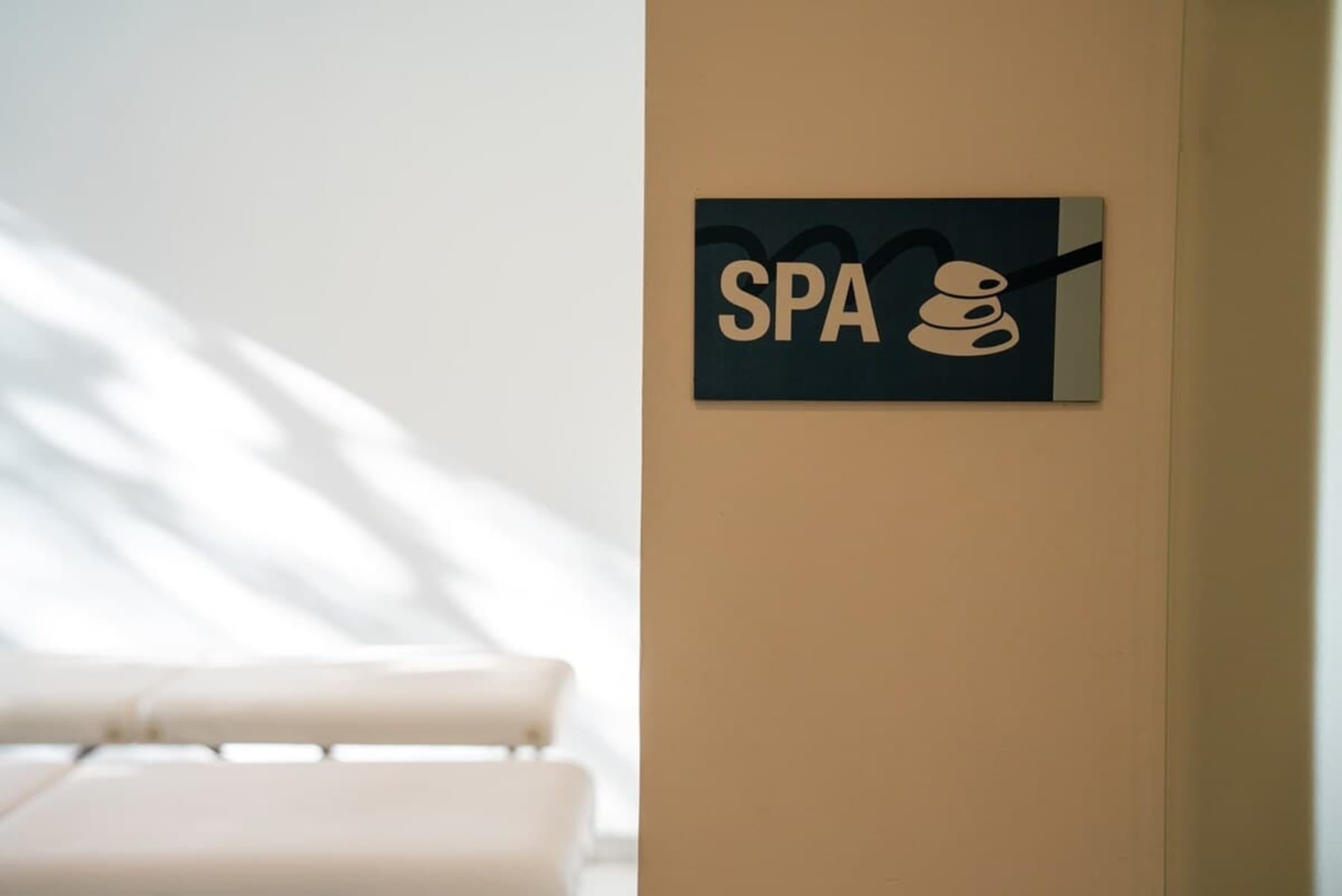 A sign on a beige wall reads "SPA" with a stacked stone logo.