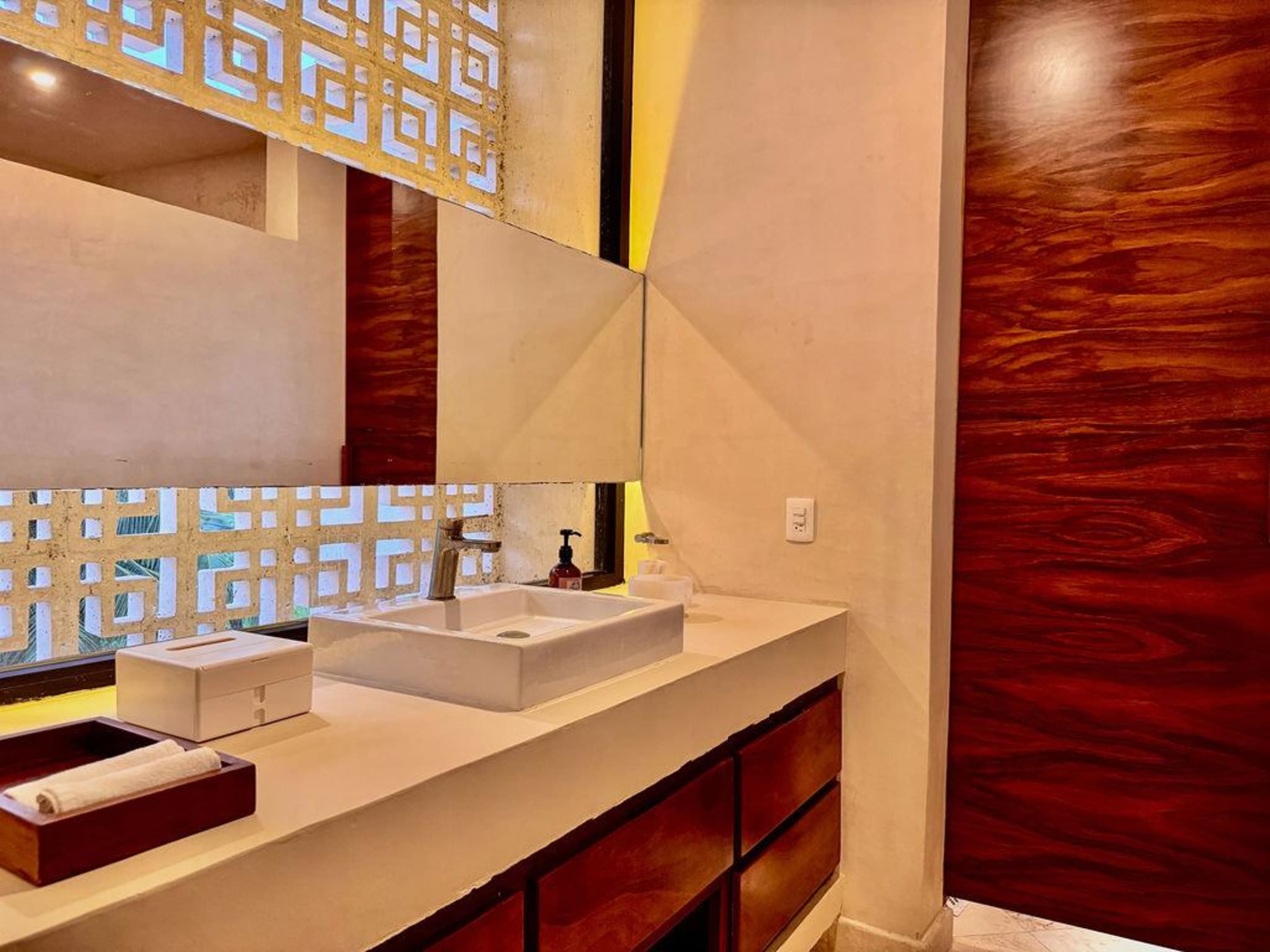 A bathroom vanity with a sink, tissue box, and folded towels.