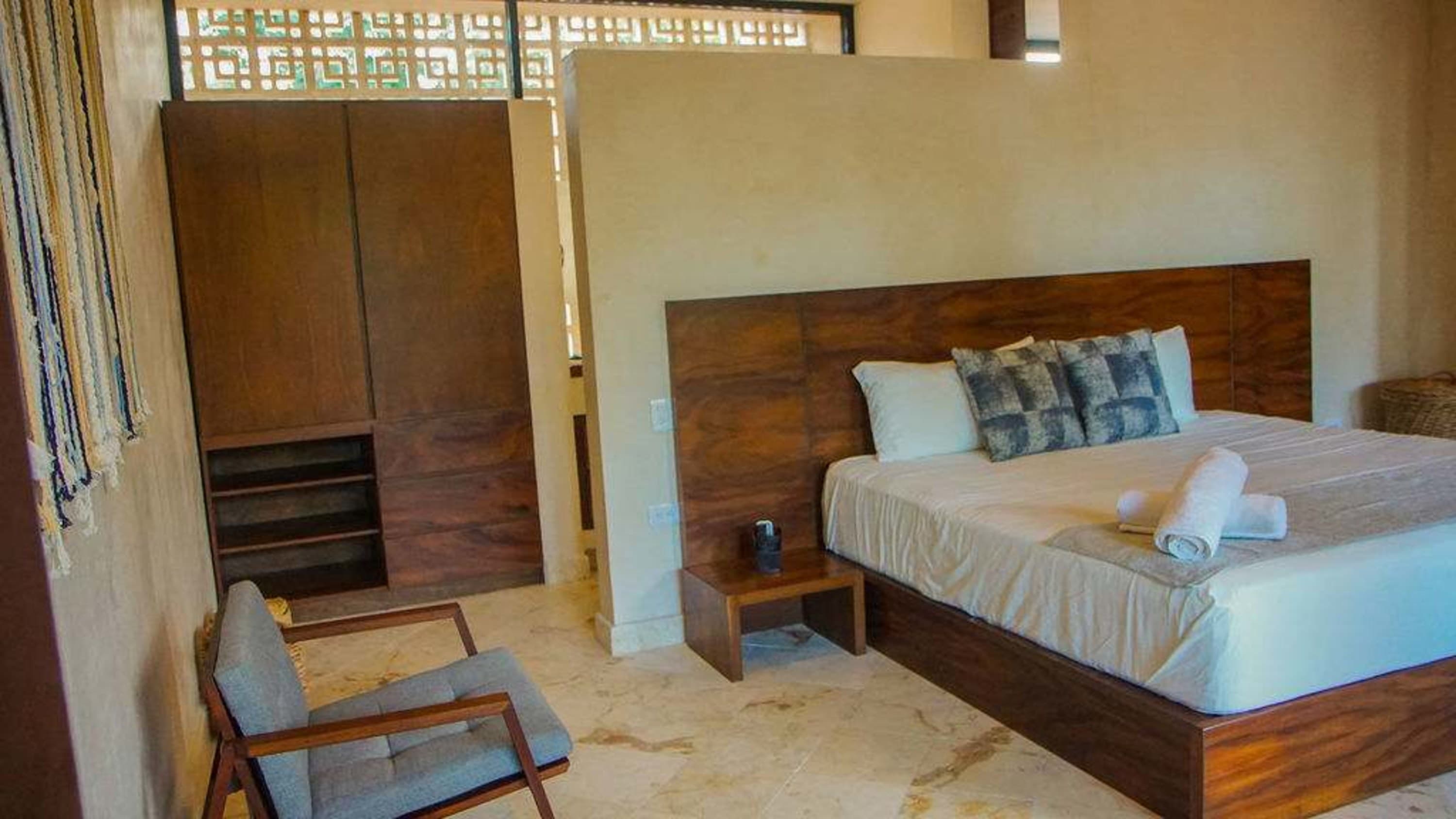 A bedroom with a wooden bed, chair, and closet.