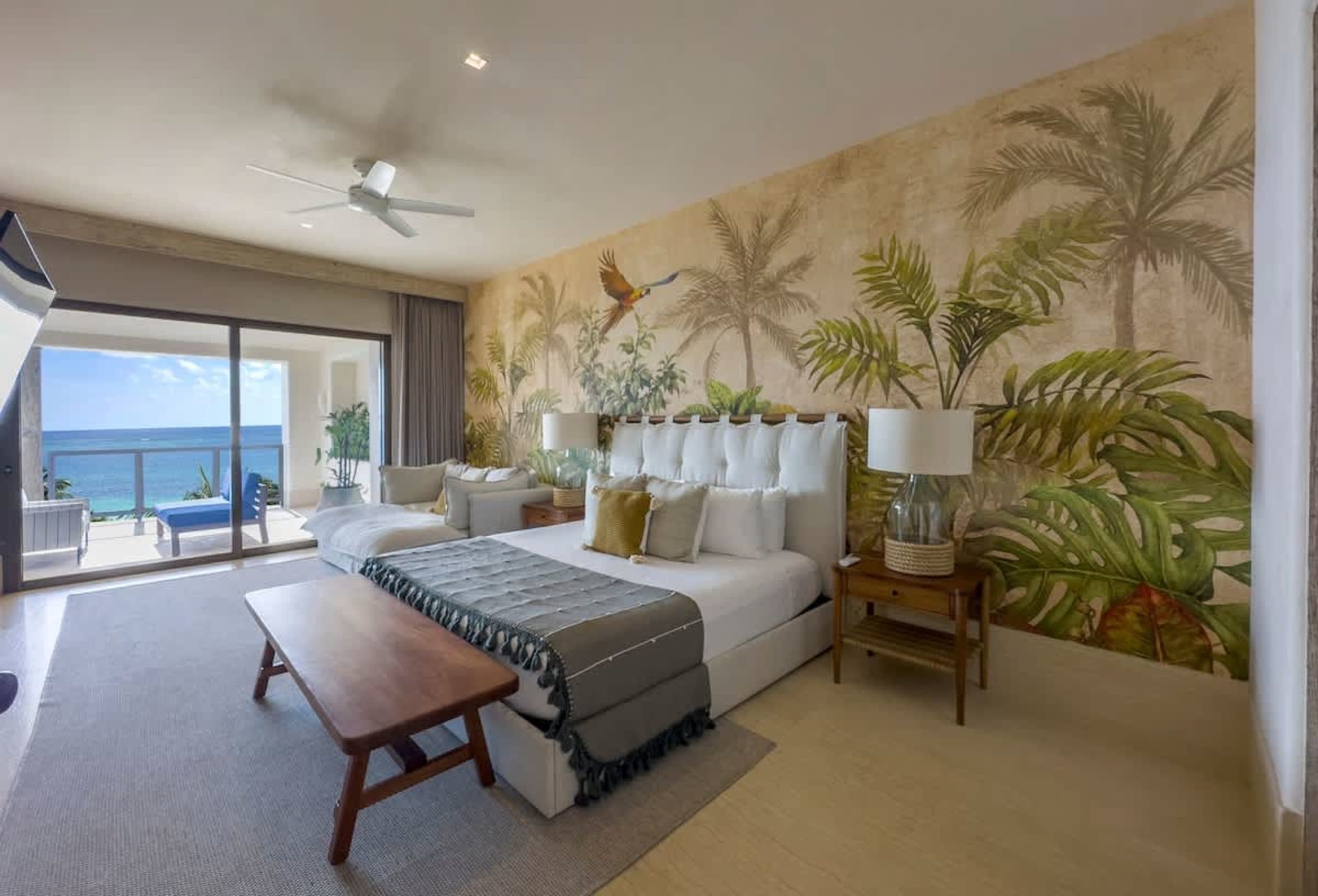 Bedroom with king bed, tropical wallpaper, and ocean view.