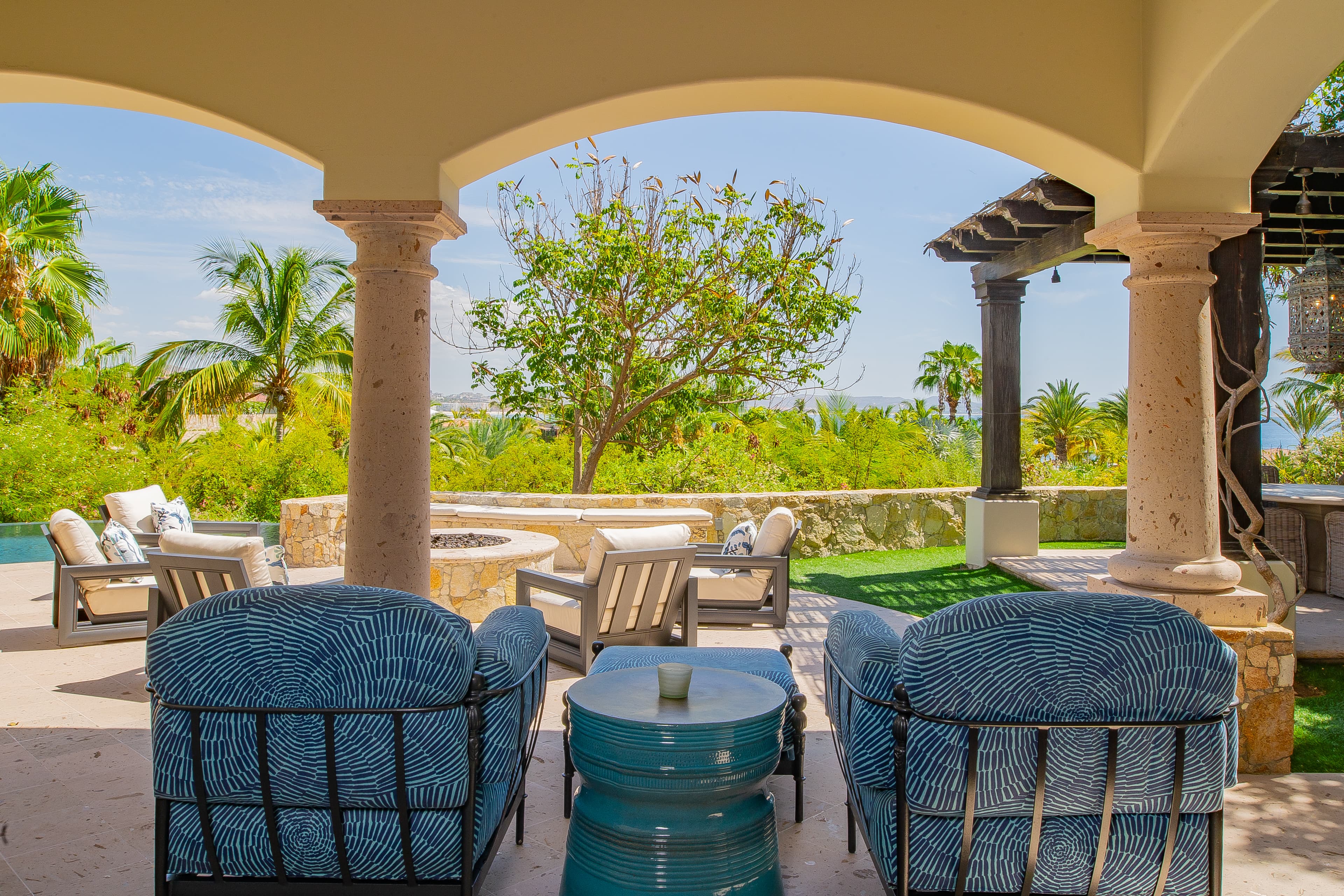 Settle into the shaded comfort of your private terrace, where elegant arches frame lush gardens and ocean glimpses beyond—perfect for sipping morning coffee or watching the day drift by.