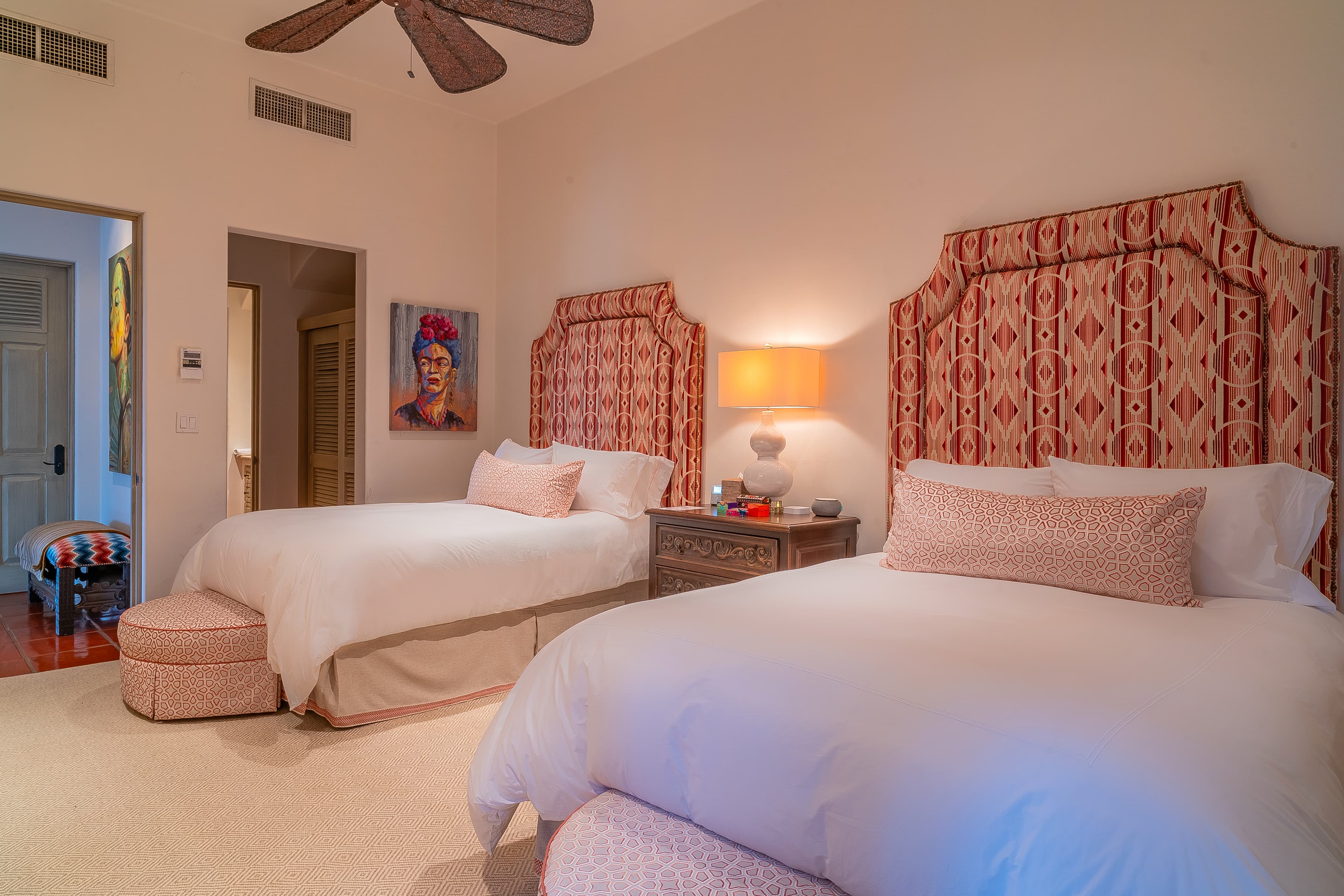 Bedroom 4 · Unwind in this spacious bedroom with twin beds dressed in crisp linens and upholstered headboards, where a ceiling fan ensures your comfort year-round.