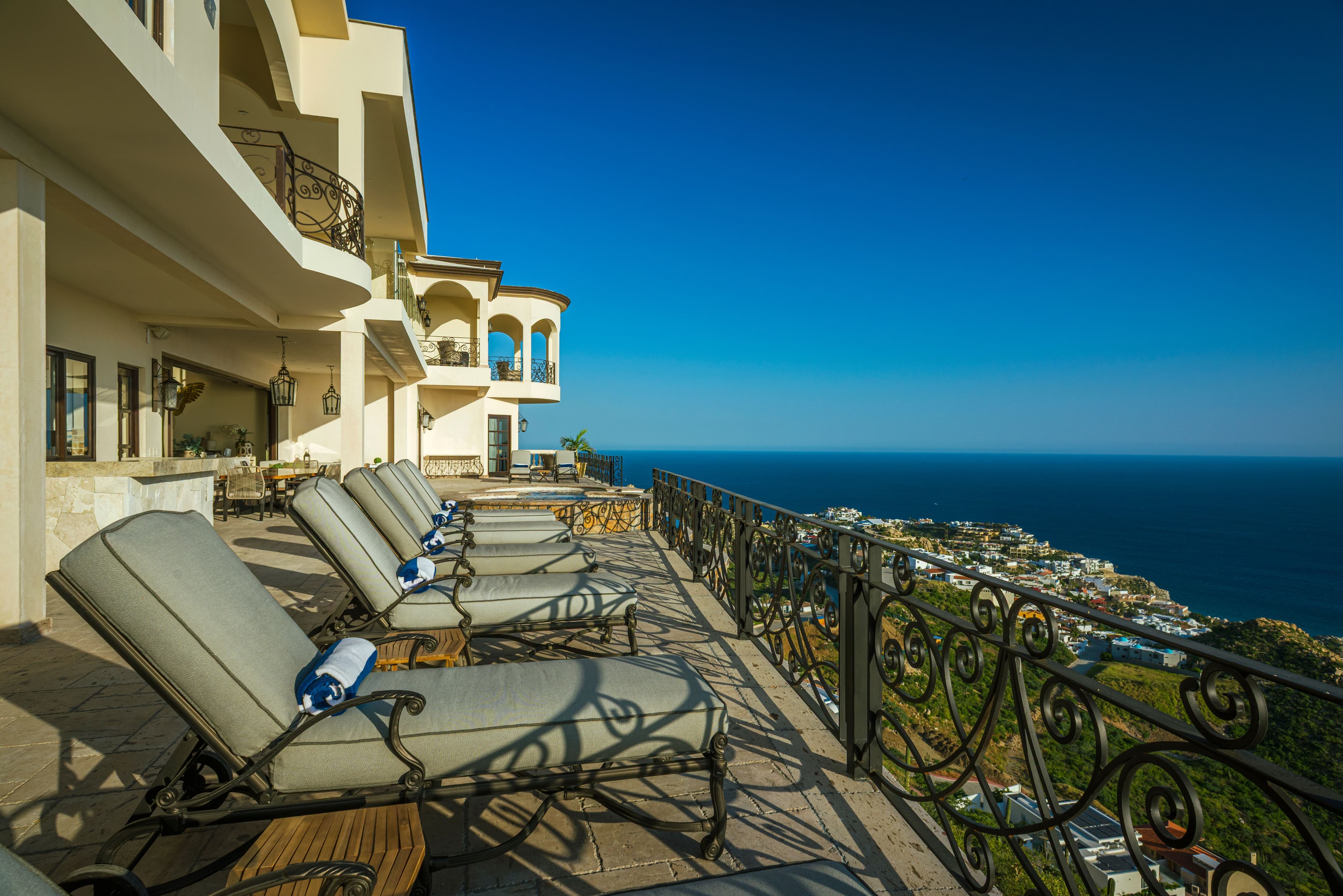 Expansive terrace with comfortable loungers overlooking stunning coastal views and blue Mediterranean waters.