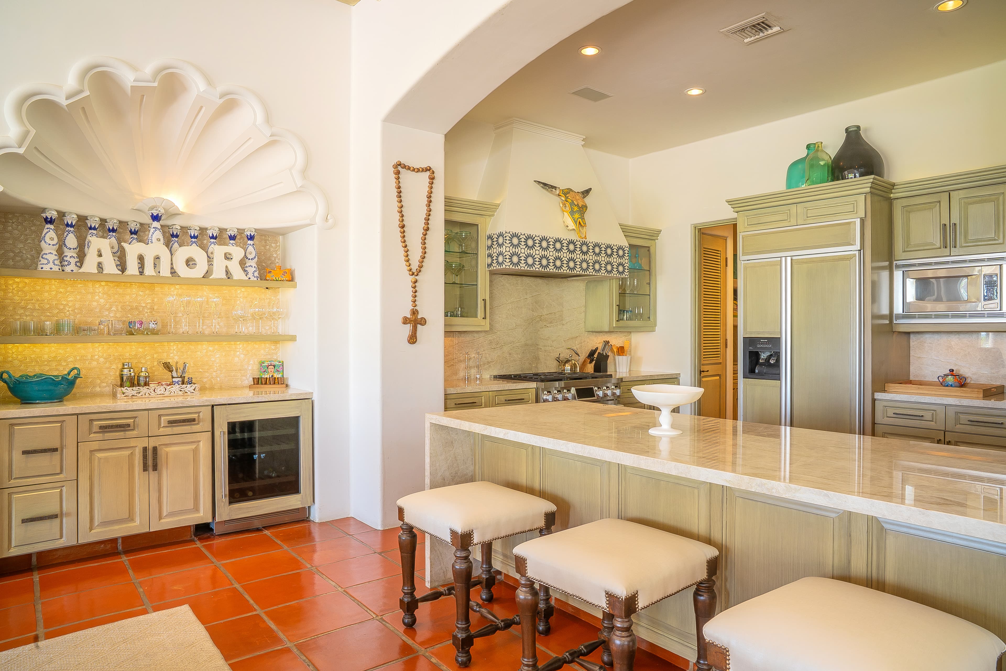 You'll love preparing meals in this charming full kitchen with terracotta floors, elegant sage cabinetry, and a welcoming breakfast bar perfect for morning coffee or casual dining with loved ones.