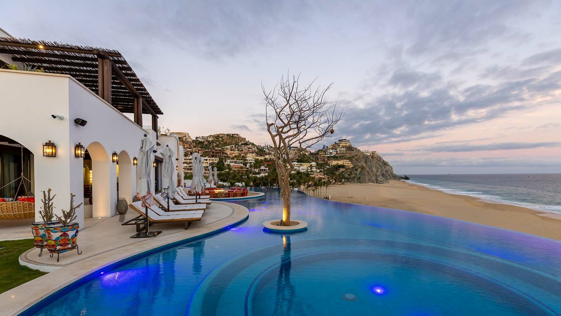A tree sits in the middle of the pool of this Los Cabos beachfront villa.