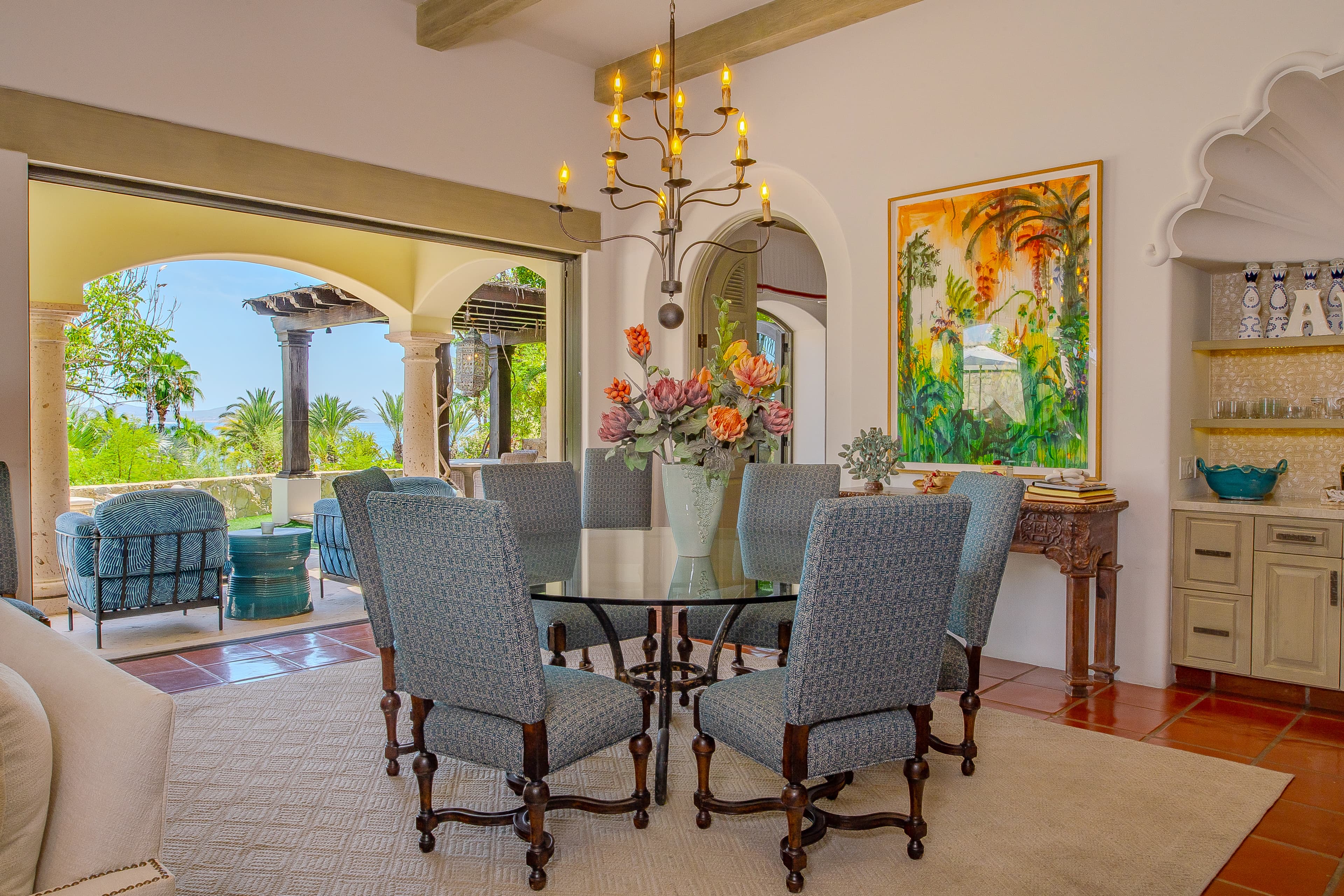Gather for unforgettable meals in this stunning dining space, where elegant furnishings meet tropical views. Sunlight pours through arched openings to your private terrace and the lush landscape beyond.