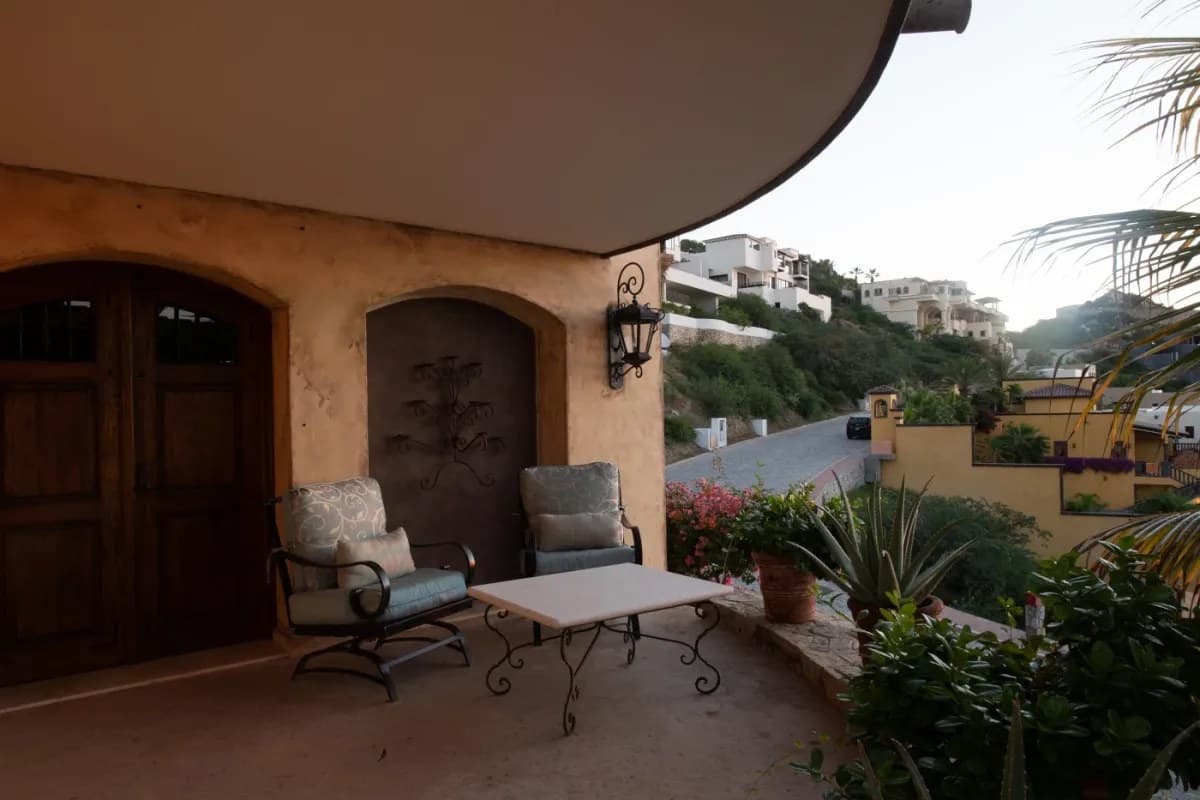 Your private terrace invites you to unwind in style, with plush seating framed by lush greenery and views of hillside homes—a perfect retreat for morning coffee or evening relaxation.