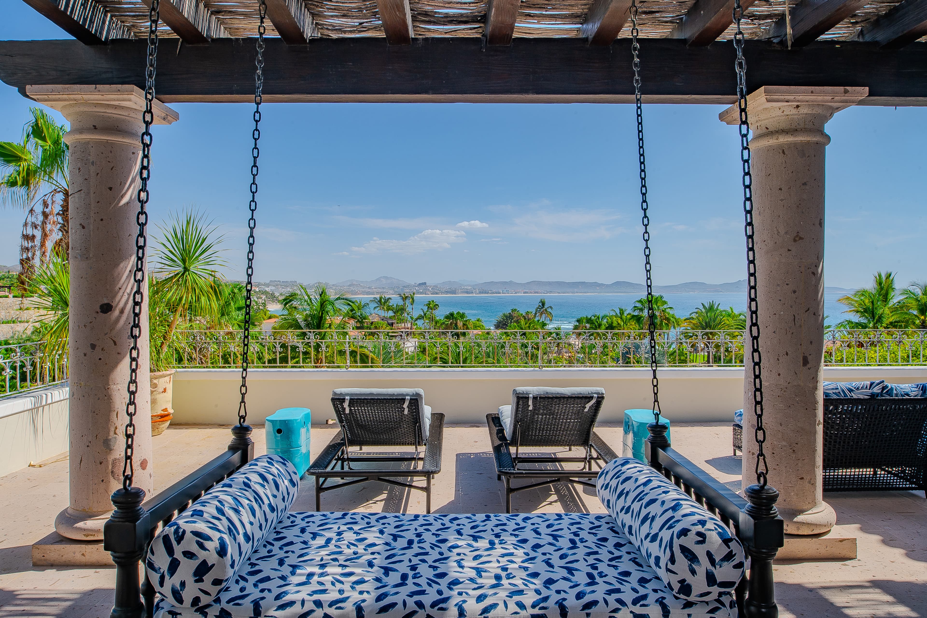 Gently sway on this luxurious hanging daybed while gazing at the turquoise sea and lush palms stretching before you—pure paradise.