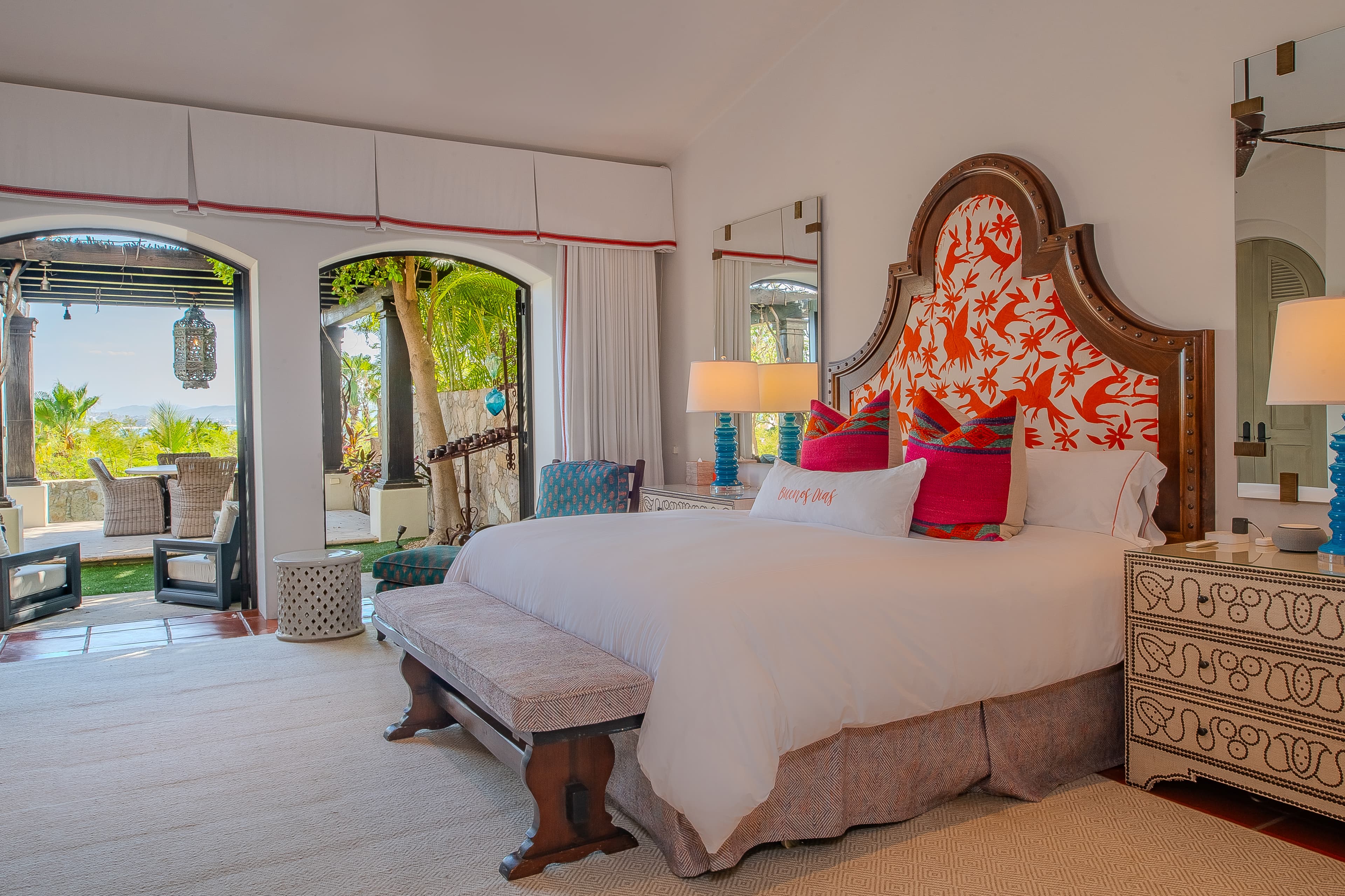 Bedroom 1 (Master) · Unwind in your elegant bedroom where tropical breezes meet vibrant design. Wake to garden views through arched doors, relax on plush seating, and sink into crisp linens.