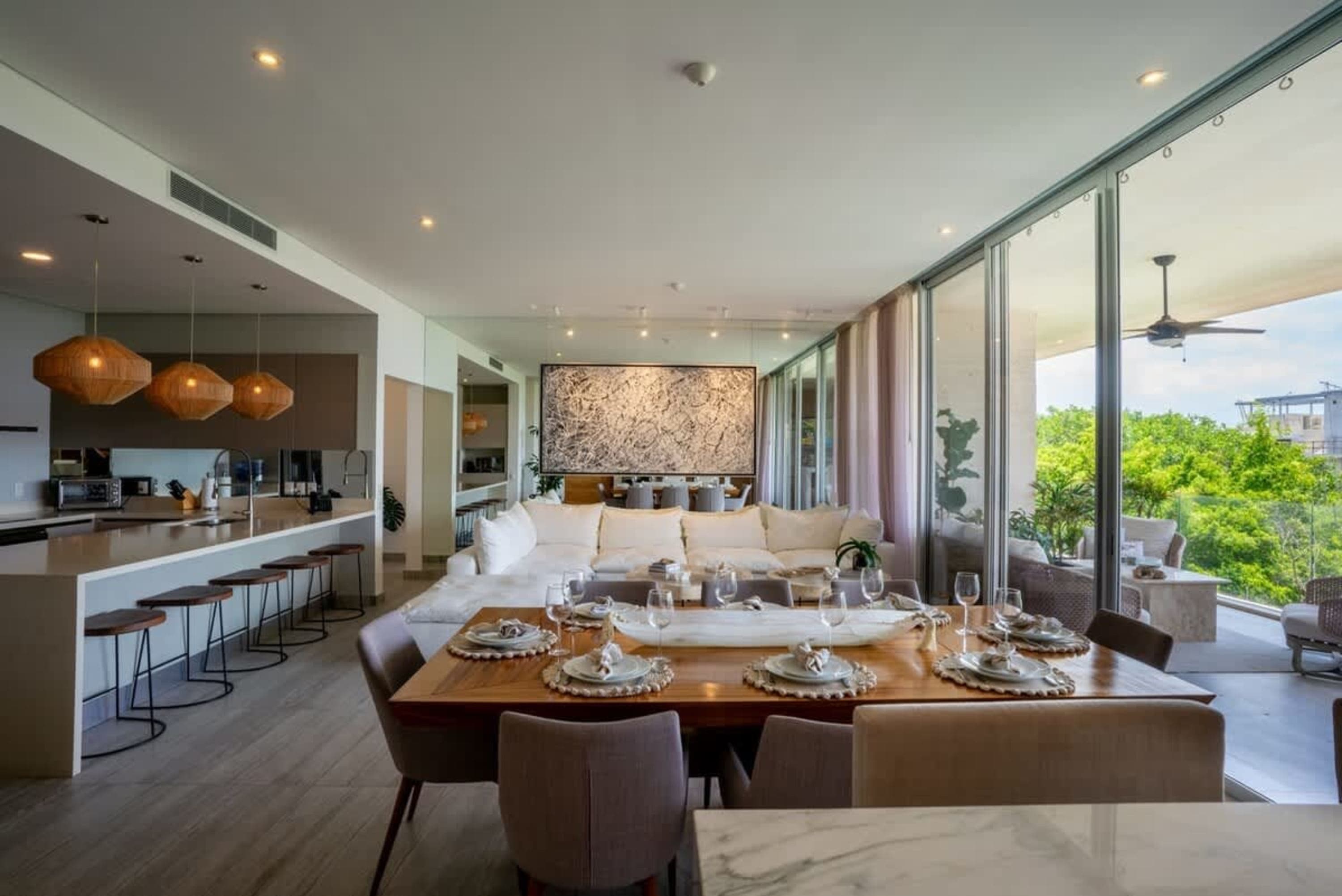 Modern open-plan living space with a kitchen, dining table, and lounge area.