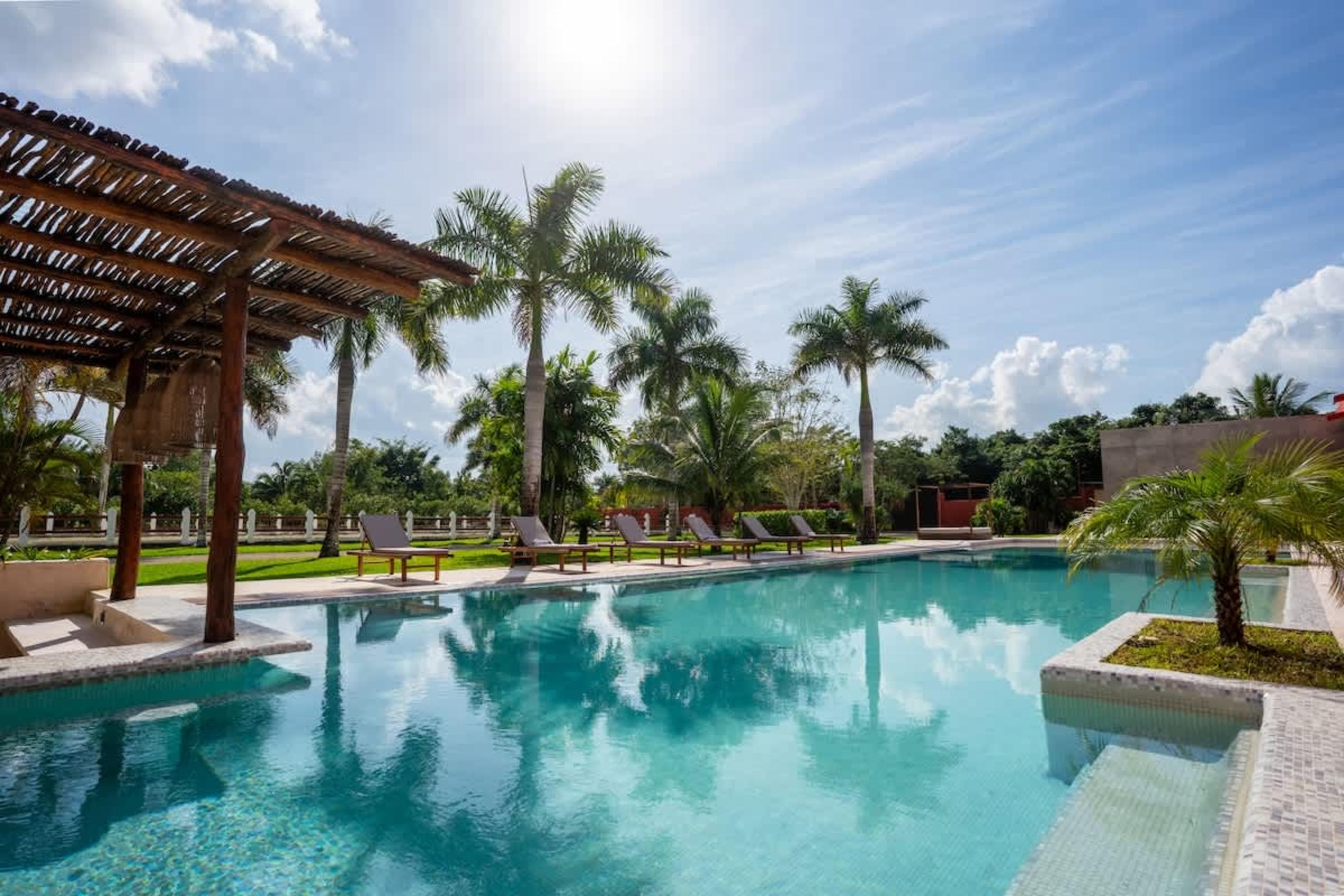 A bright, sunny day with a clear blue sky over a swimming pool.