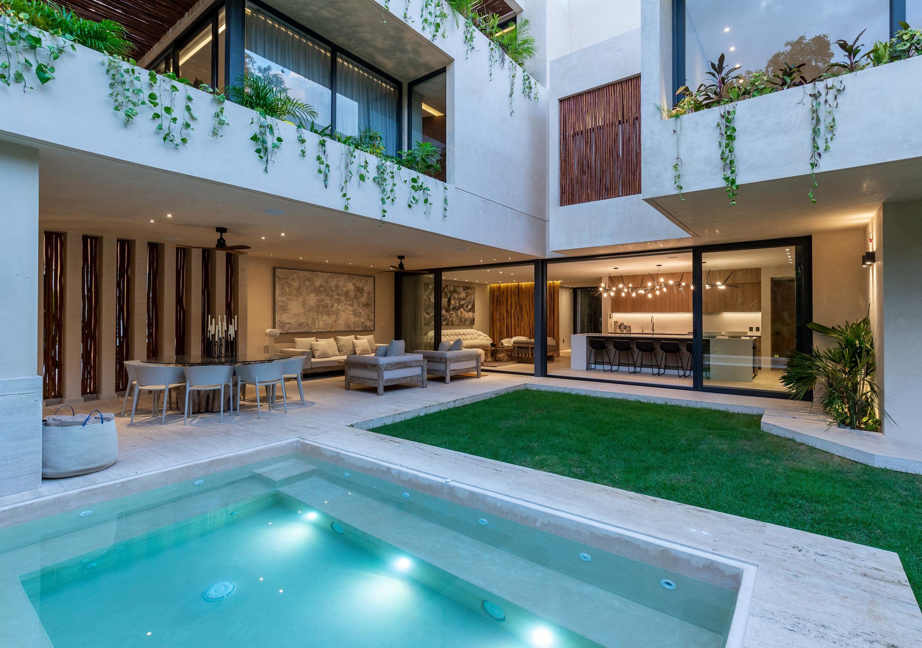 Modern patio with a pool, dining area, lounge, and kitchen.